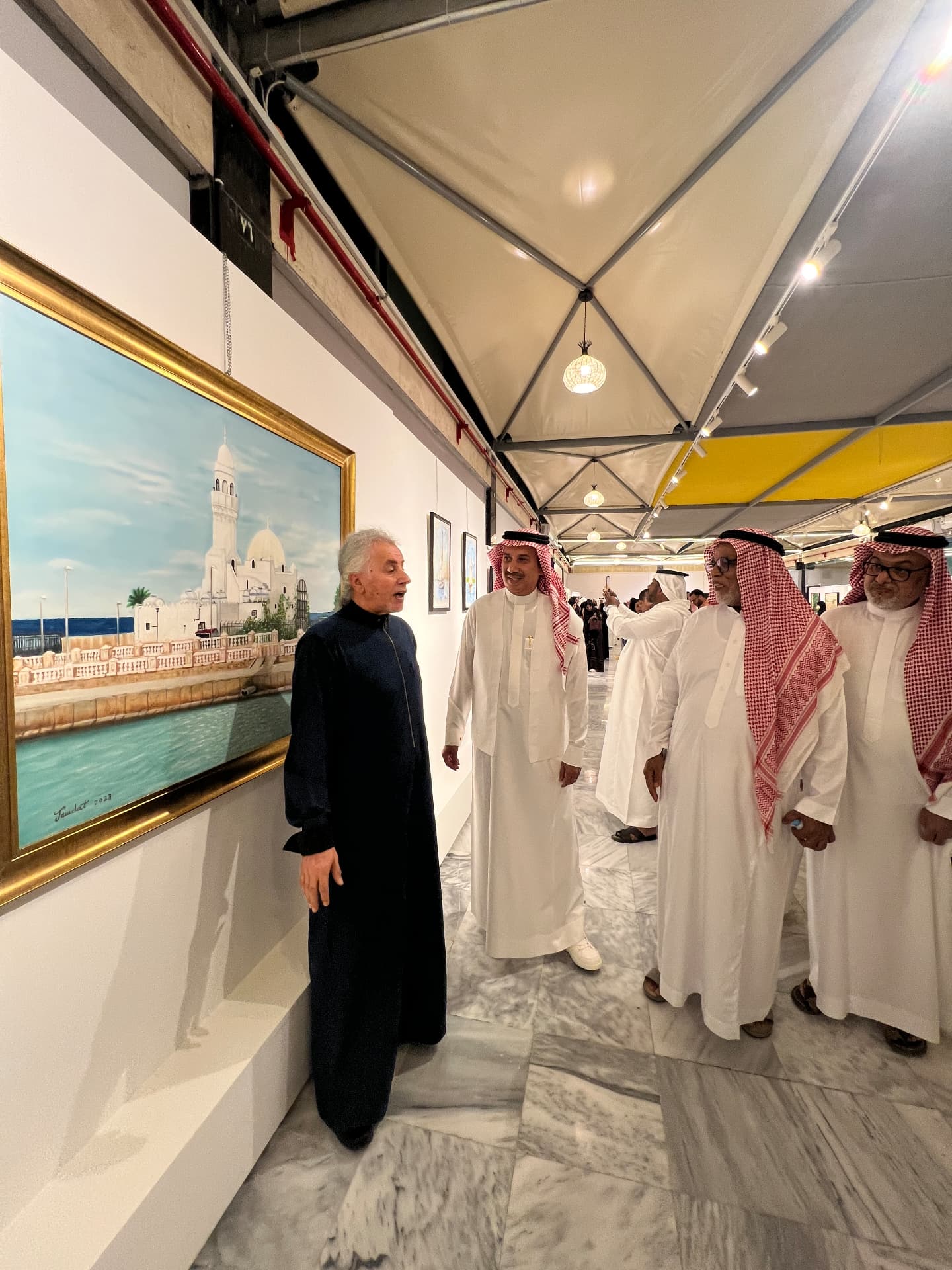 Guest curator presenting a painting to visiting dignitaries